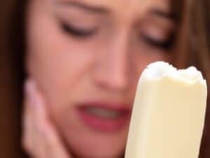 A Woman With Sensitive Teeth And Cold Ice Cream